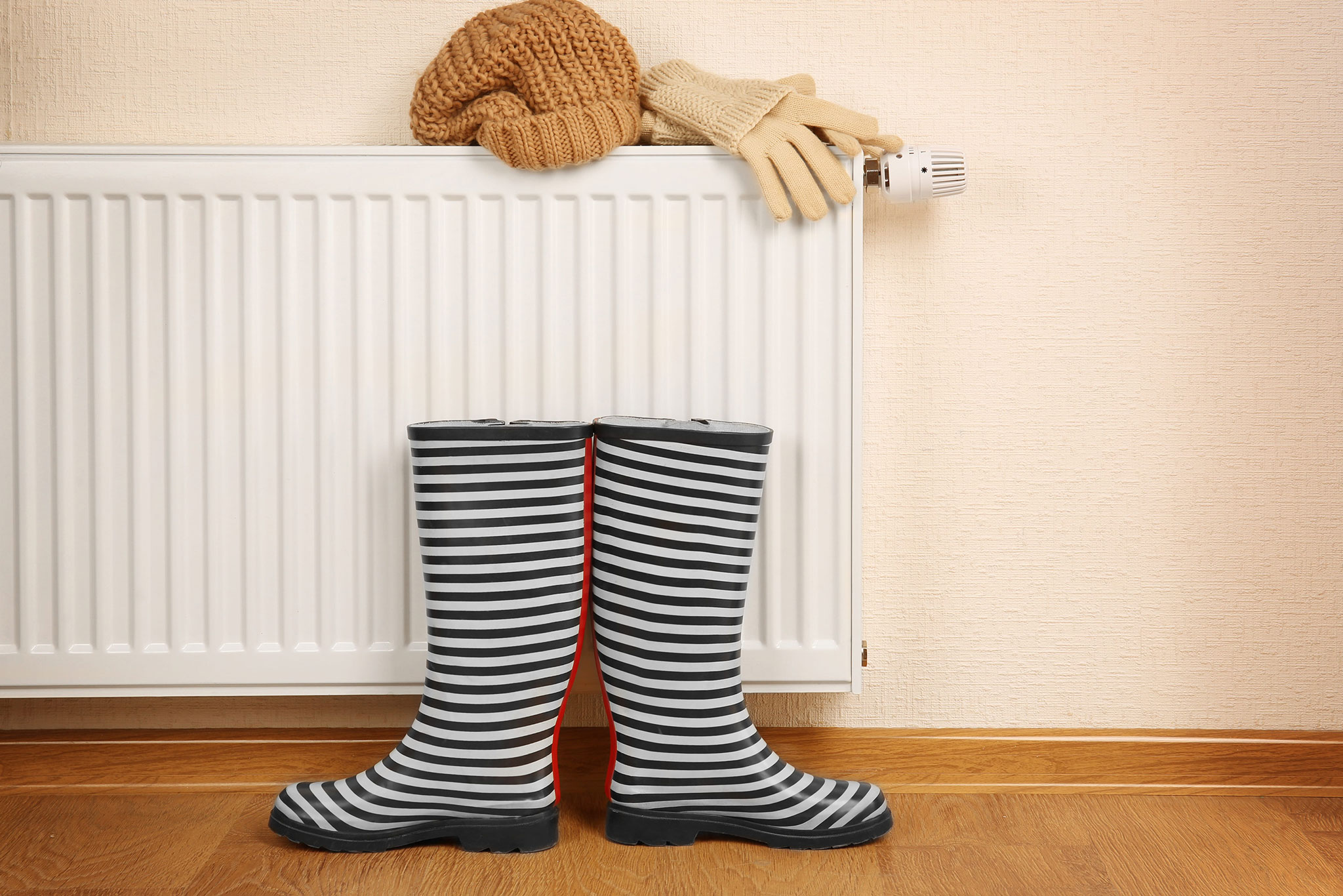 A Pair Of Wellington Boots By A Radiator