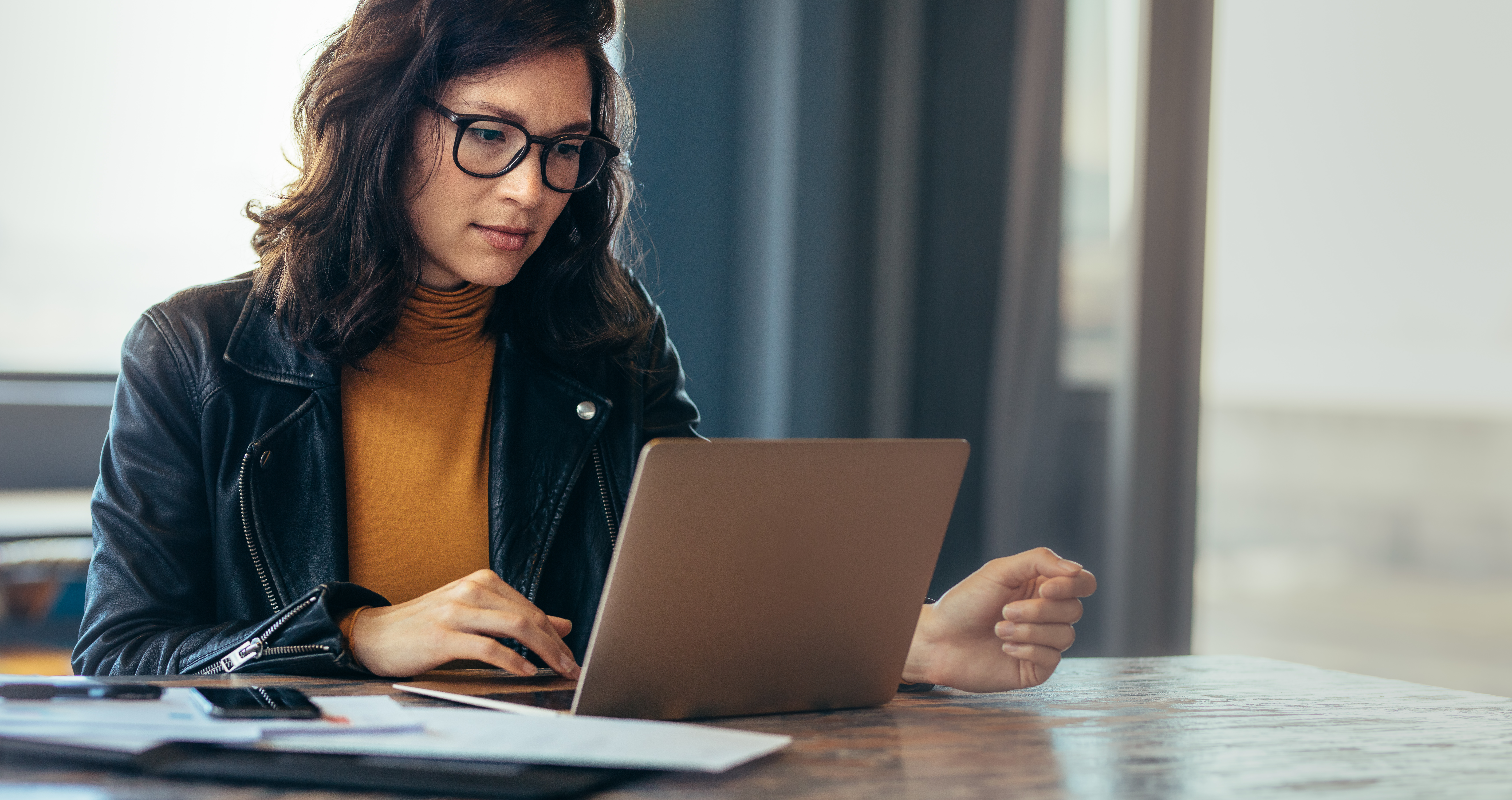 Woman with glasses working on laptop